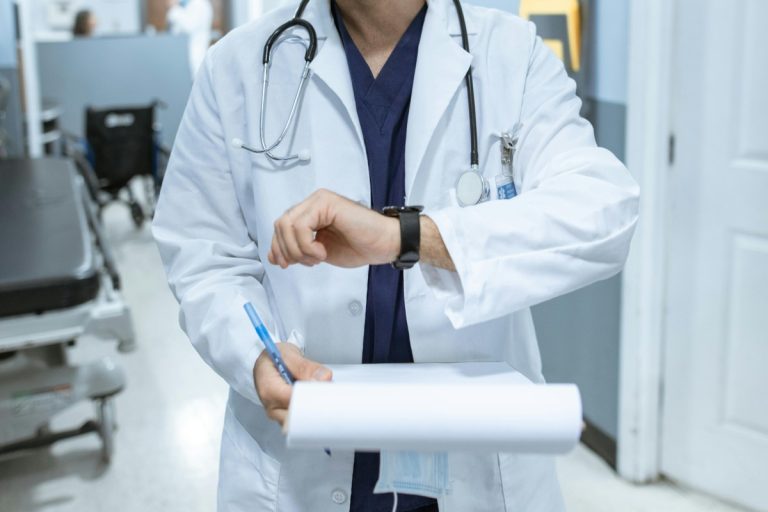 Doctor in a white coat checking the time, symbolizing long wait times in healthcare in Quebec.