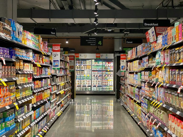 An aisle in a Canadian grocery store with a dairy section, illustrating smart savings in Canada.