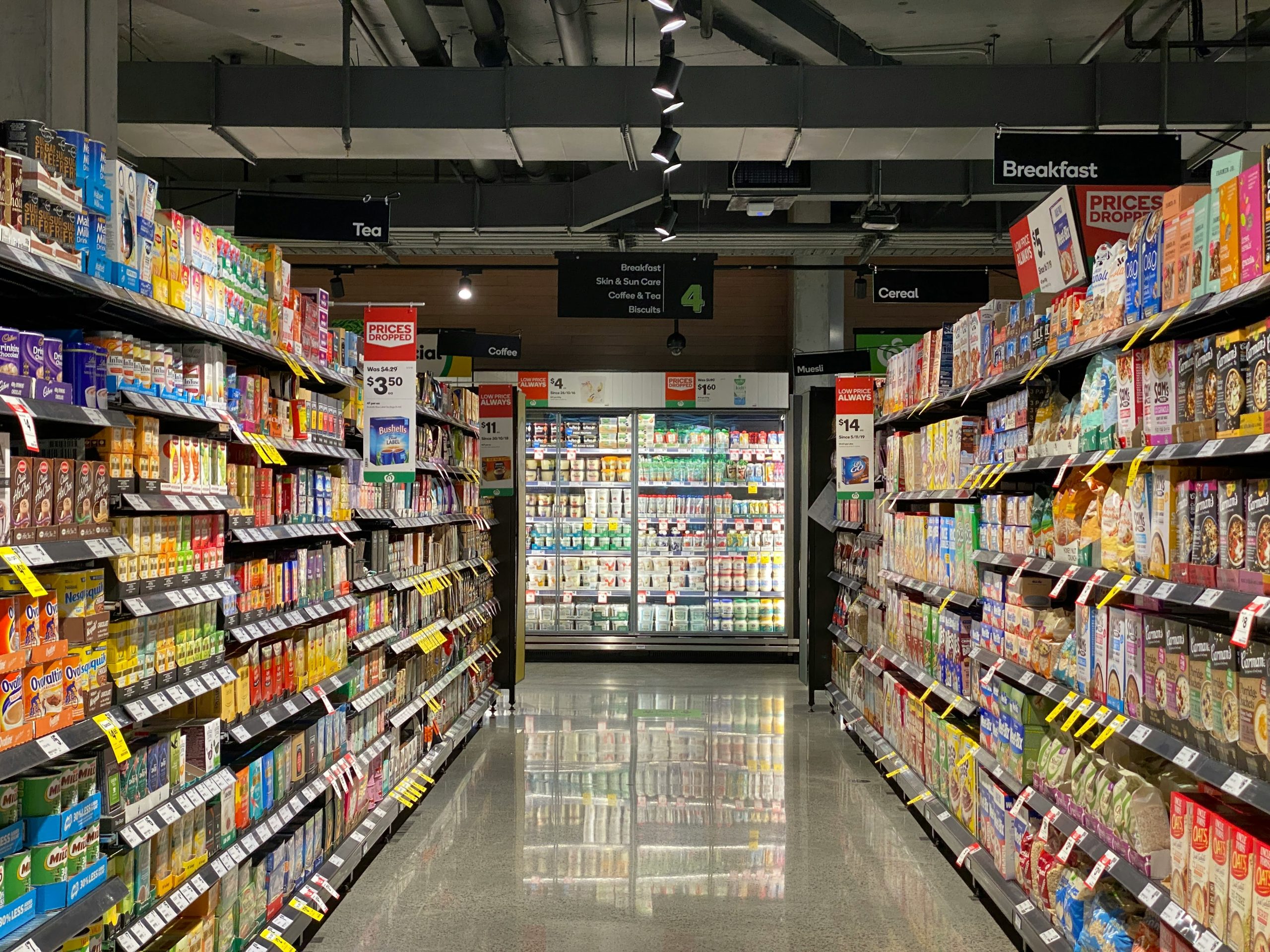 An aisle in a Canadian grocery store with a dairy section, illustrating smart savings in Canada.